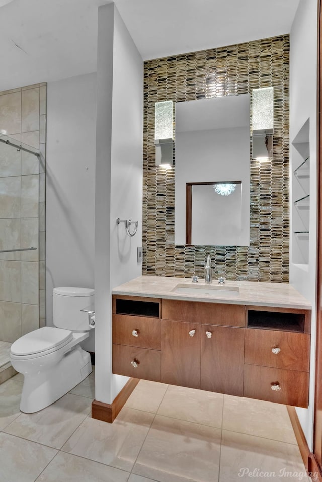 bathroom with backsplash, vanity, a shower, tile patterned floors, and toilet