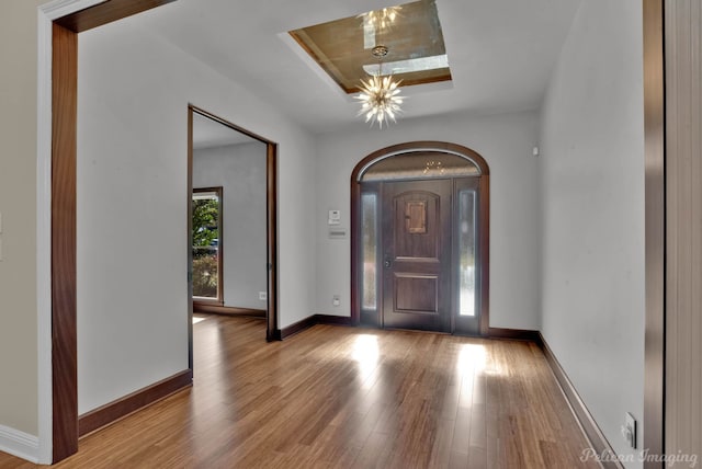 entrance foyer with hardwood / wood-style flooring and a raised ceiling