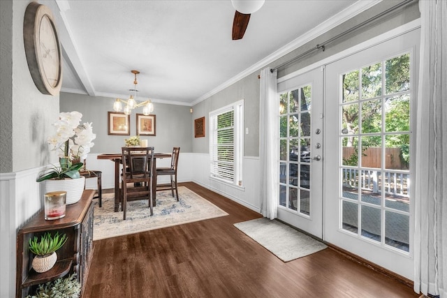 dining area featuring ornamental molding, dark wood-type flooring, ceiling fan with notable chandelier, and french doors