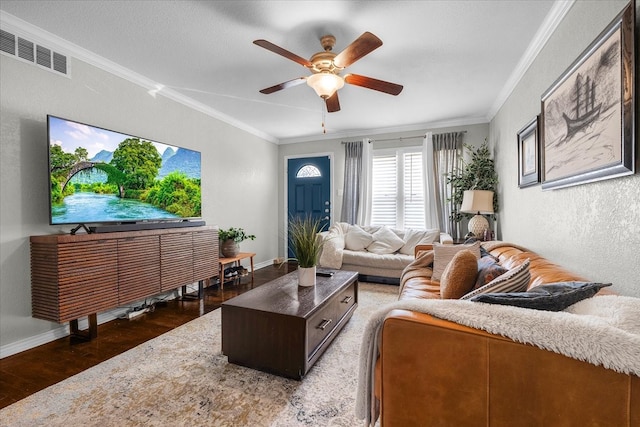 living room with crown molding, dark wood-type flooring, and ceiling fan