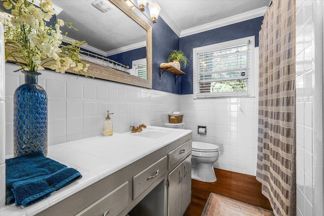 bathroom with a textured ceiling, toilet, tile walls, vanity, and hardwood / wood-style flooring