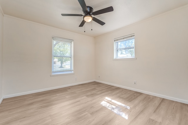 spare room featuring ceiling fan, a healthy amount of sunlight, ornamental molding, and light wood-type flooring