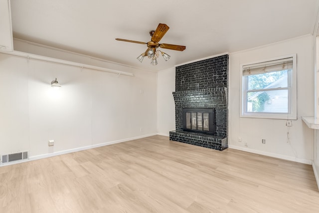 unfurnished living room with ornamental molding, light hardwood / wood-style flooring, a fireplace, and ceiling fan