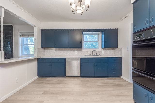 kitchen with sink, blue cabinetry, dishwasher, and a wealth of natural light