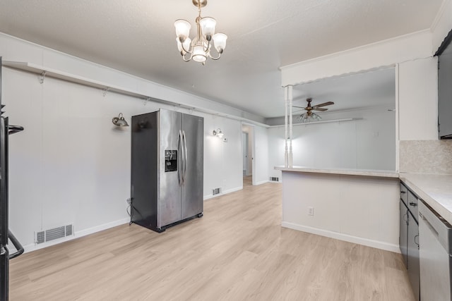 kitchen featuring decorative backsplash, light hardwood / wood-style floors, stainless steel appliances, a textured ceiling, and ceiling fan with notable chandelier