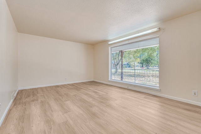 empty room featuring light hardwood / wood-style floors and a textured ceiling