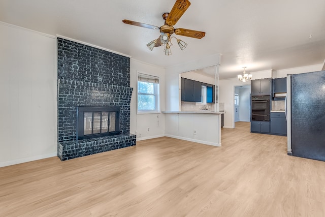 unfurnished living room with light hardwood / wood-style floors, crown molding, and a brick fireplace