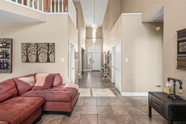 living room with a towering ceiling and tile patterned flooring