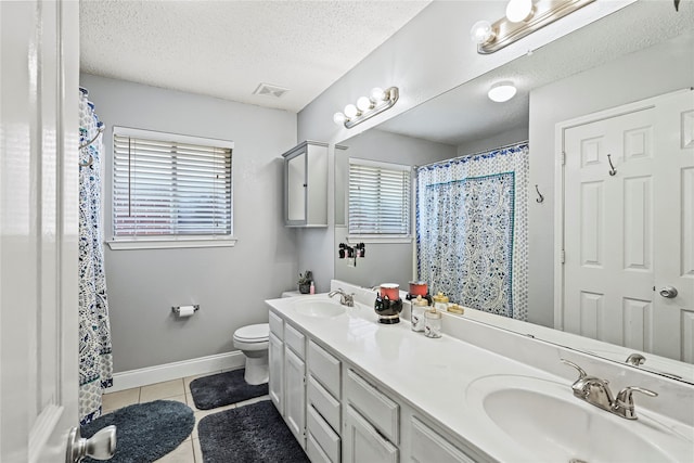 bathroom with vanity, a textured ceiling, toilet, and tile patterned flooring