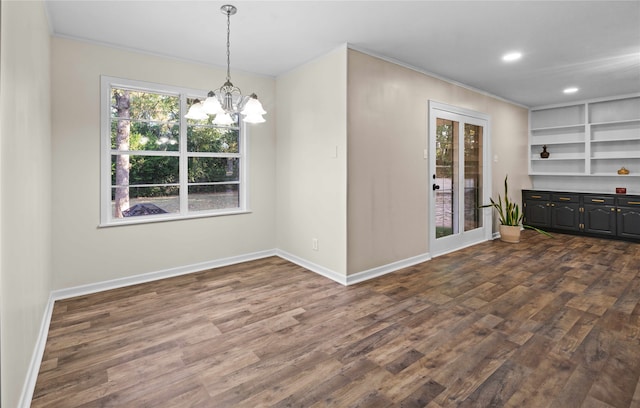 unfurnished dining area with a chandelier, crown molding, and dark hardwood / wood-style floors