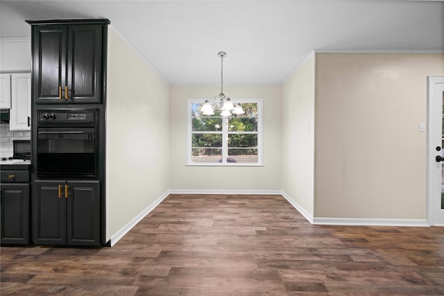 unfurnished dining area featuring an inviting chandelier, dark hardwood / wood-style floors, and crown molding