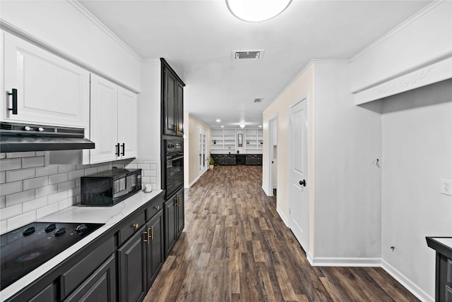 kitchen with tasteful backsplash, black appliances, white cabinets, dark wood-type flooring, and ornamental molding