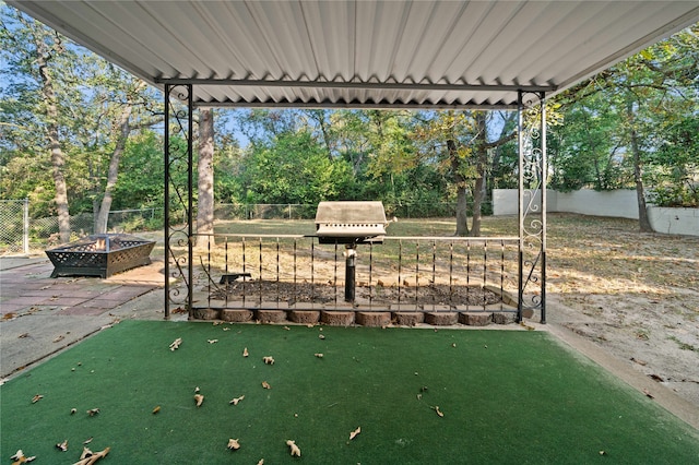 view of patio with area for grilling and a fire pit