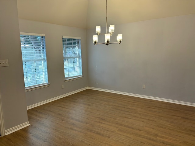 unfurnished room with dark hardwood / wood-style flooring and an inviting chandelier