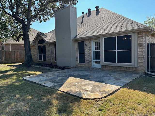 rear view of house featuring a patio area and a lawn