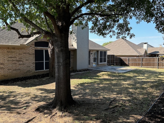 rear view of house with a patio and a lawn