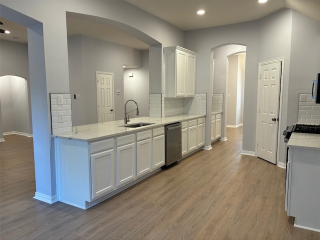 kitchen with white cabinetry, tasteful backsplash, light stone counters, and light wood-type flooring