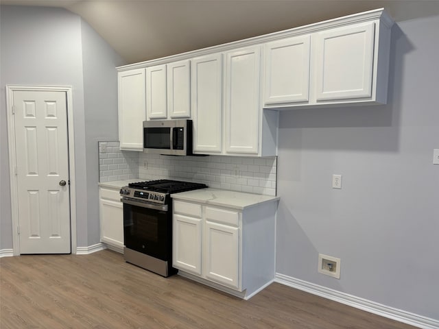 kitchen featuring appliances with stainless steel finishes, white cabinets, and light hardwood / wood-style floors