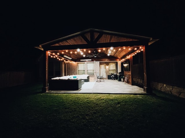 patio at twilight with outdoor lounge area, a yard, and ceiling fan