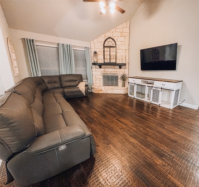 living room with hardwood / wood-style floors, a stone fireplace, vaulted ceiling, and ceiling fan