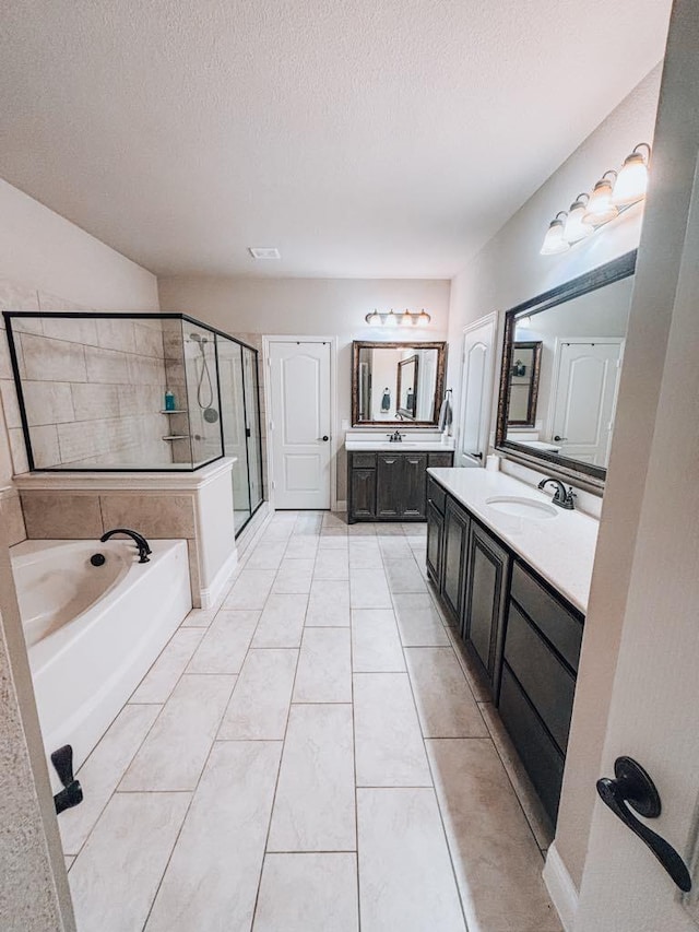 bathroom featuring tile patterned floors, vanity, independent shower and bath, and a textured ceiling