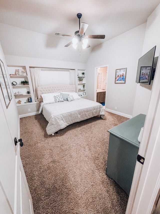 bedroom with vaulted ceiling, carpet, ensuite bathroom, and ceiling fan