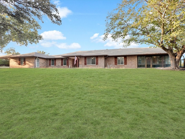 view of front of home featuring brick siding and a front lawn
