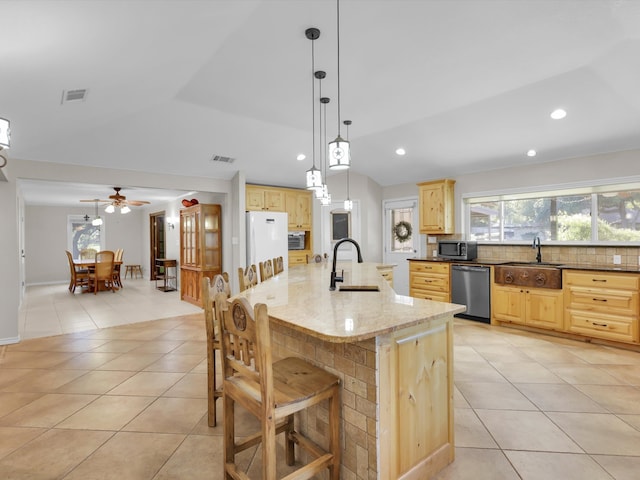 kitchen featuring a spacious island, stainless steel appliances, light brown cabinetry, and sink