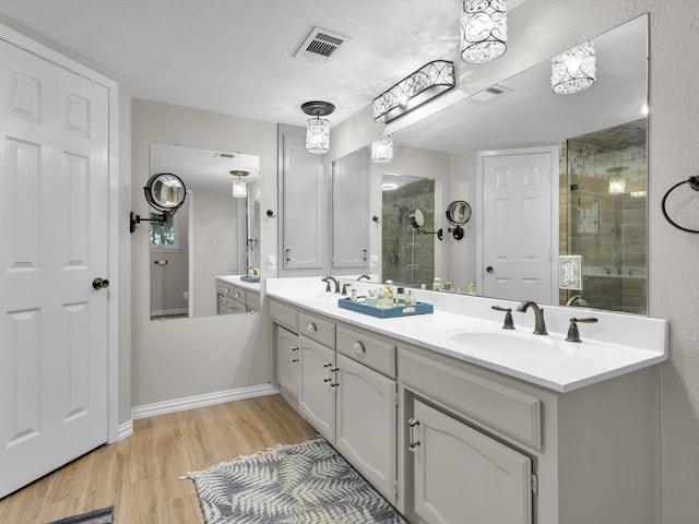 bathroom with vanity, hardwood / wood-style floors, and a shower with shower door