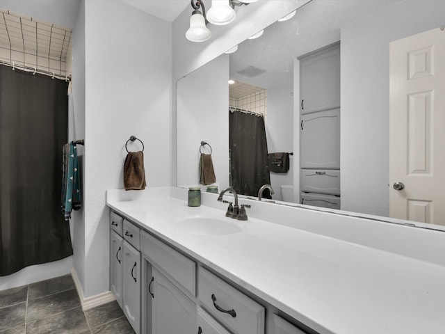 full bathroom with baseboards, a shower with shower curtain, toilet, and vanity