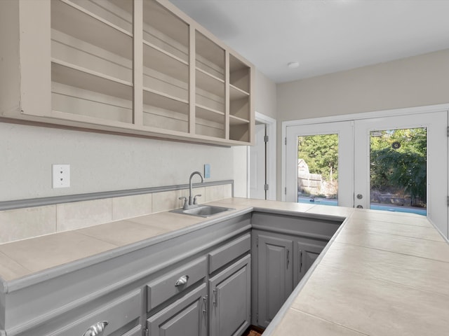 kitchen with french doors, tile countertops, sink, and gray cabinets