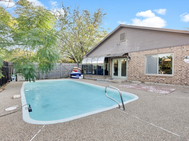 view of swimming pool with a patio area and french doors