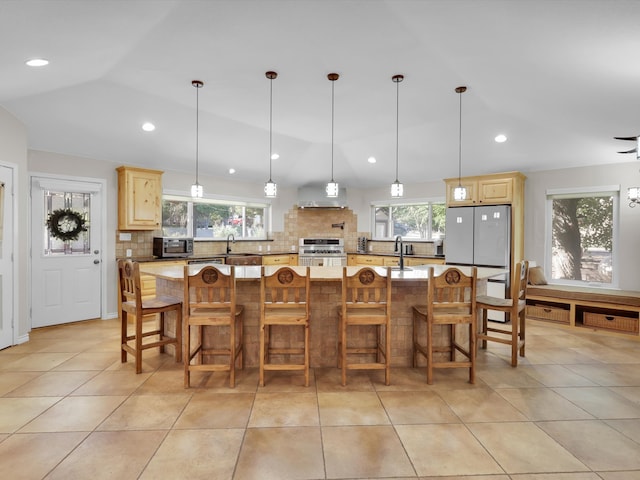 kitchen featuring a large island, lofted ceiling, tasteful backsplash, and appliances with stainless steel finishes