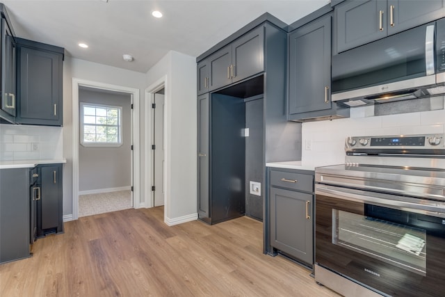 kitchen with appliances with stainless steel finishes, light hardwood / wood-style flooring, and tasteful backsplash