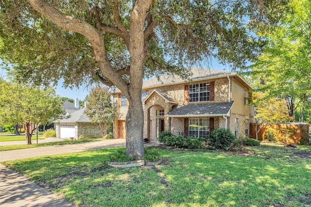 traditional-style house featuring brick siding, driveway, a front yard, and fence