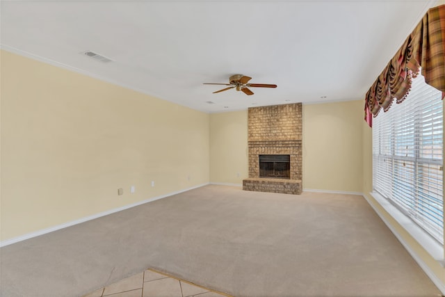 unfurnished living room featuring a brick fireplace, light colored carpet, and ceiling fan