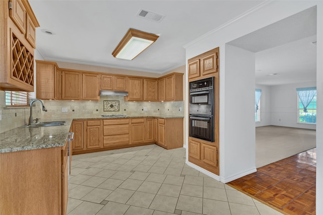 kitchen featuring crown molding, double oven, sink, light tile patterned floors, and light stone counters