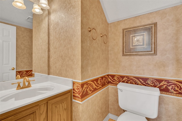 bathroom with a textured ceiling, toilet, wallpapered walls, and vanity