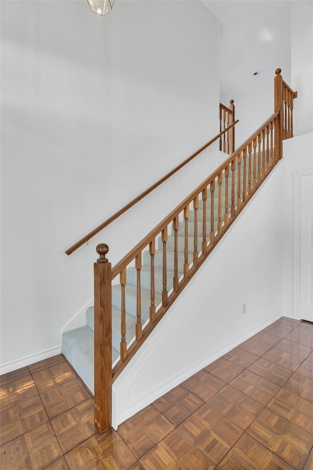 staircase featuring parquet flooring