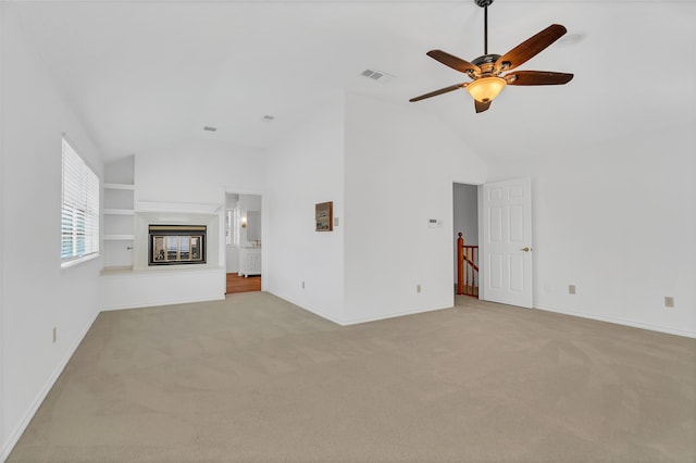 unfurnished living room with light colored carpet, vaulted ceiling, and ceiling fan