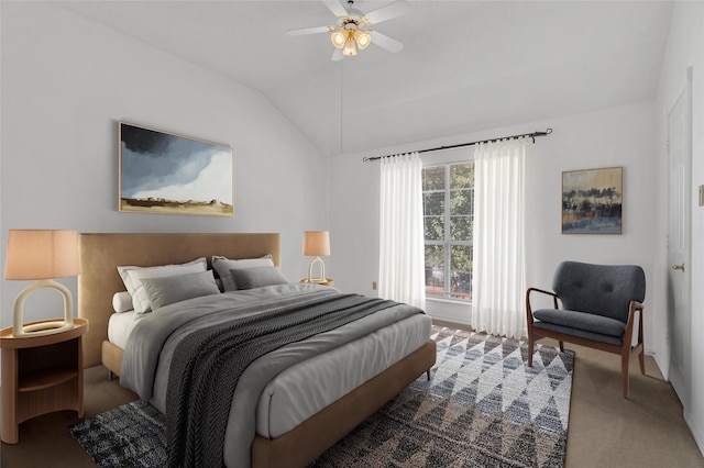 carpeted bedroom with ceiling fan and vaulted ceiling