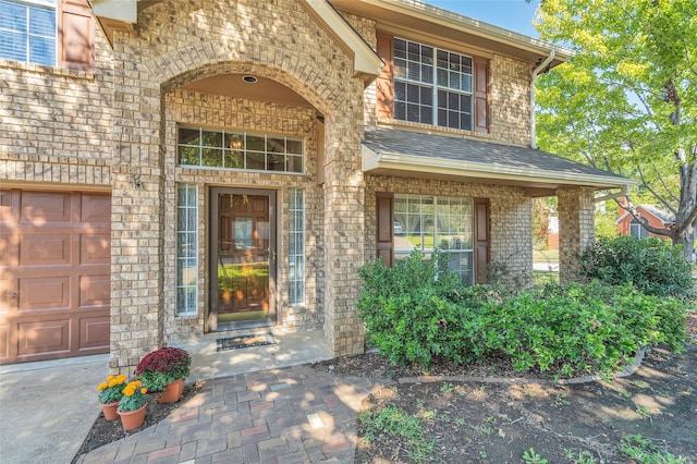 doorway to property with brick siding and roof with shingles