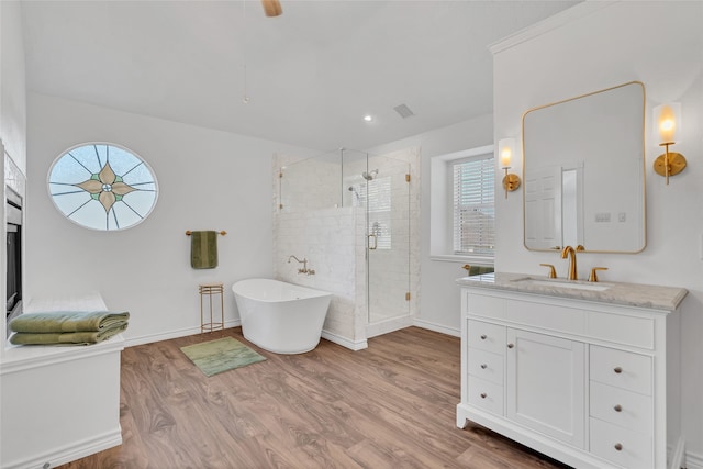 bathroom featuring a freestanding tub, wood finished floors, plenty of natural light, and a stall shower