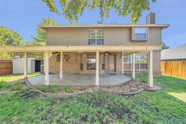 rear view of property featuring a storage shed, a yard, a fenced backyard, an outbuilding, and a patio