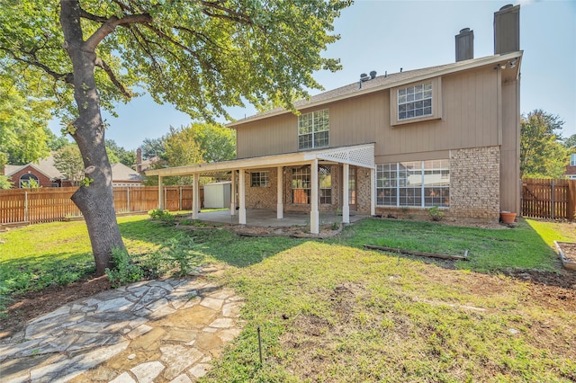 back of house with a patio and a yard