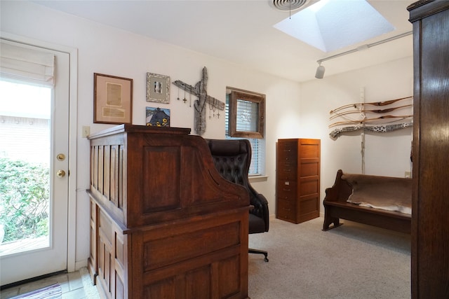 carpeted home office featuring a skylight