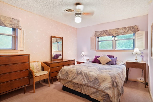 bedroom with light carpet, a textured ceiling, and ceiling fan