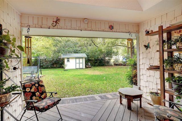 wooden deck featuring a storage shed, a yard, and a trampoline