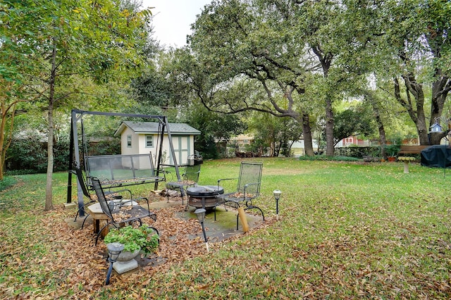 view of yard featuring a fire pit and an outbuilding