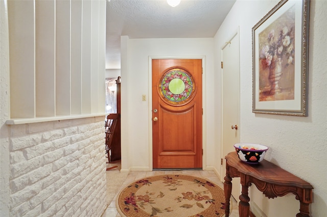 entryway featuring a textured ceiling and light tile patterned floors